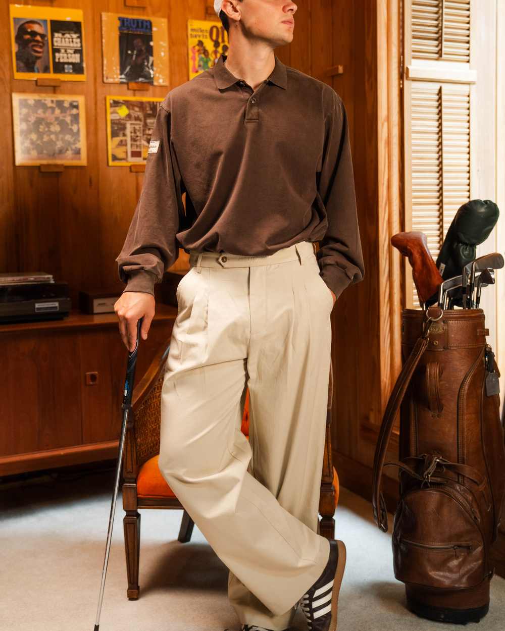 Detail shot of the black Perfect Trouser, black cable knit sweater vest, and plaid wool cap on The Golfer